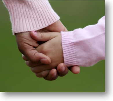 woman holds childs hand