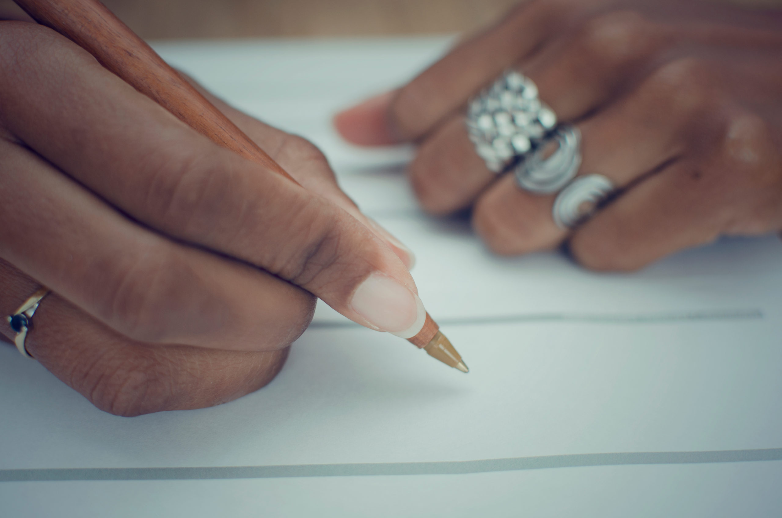 Brown hands with pen and paper